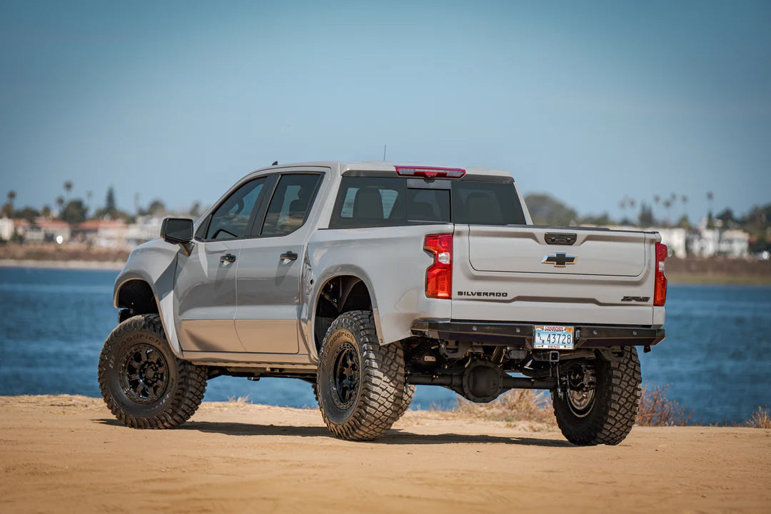 2023 Chevy Silverado showcasing unique Carbon Fiber Bedsides by Fiber Werx, parked by the lake with a beautiful seaside view.
