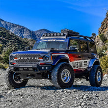 Load image into Gallery viewer, Ford Bronco equipped with Superwinch Hidden Winch Mount, demonstrating enhanced off-road styling and functionality on rocky terrain.