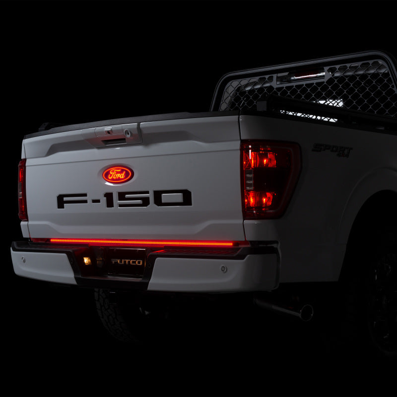 Rear view of a Putco 2021+ Ford F150 equipped with a 60 inch Freedom Blade LED Tailgate Light Bar, displaying stunning red illumination for safety and style.