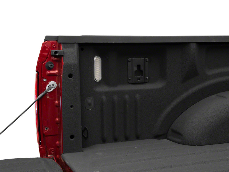 Raxiom Axial Series LED Cargo Light installed in the bed of a Ford F-150, showcasing the vehicle's interior and cargo area.