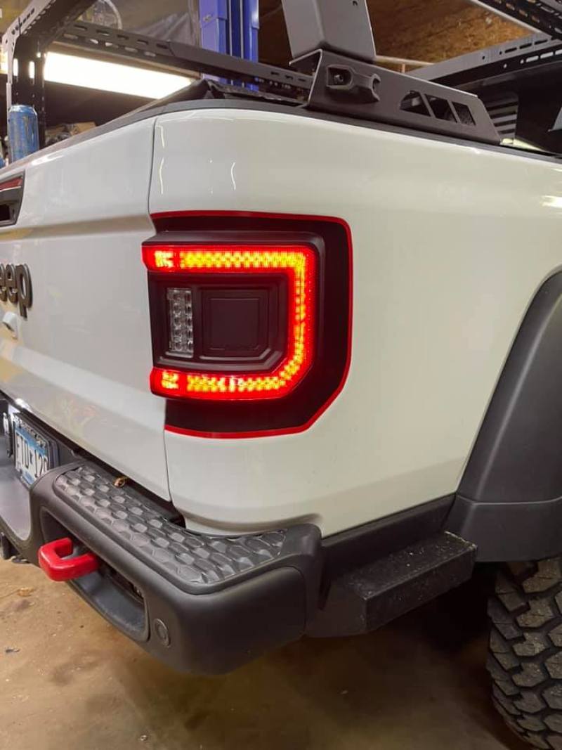Jeep Gladiator JT illuminated with ORACLE Lighting Flush Mount LED Tail Lights, capturing the sleek wrap-around feature.
