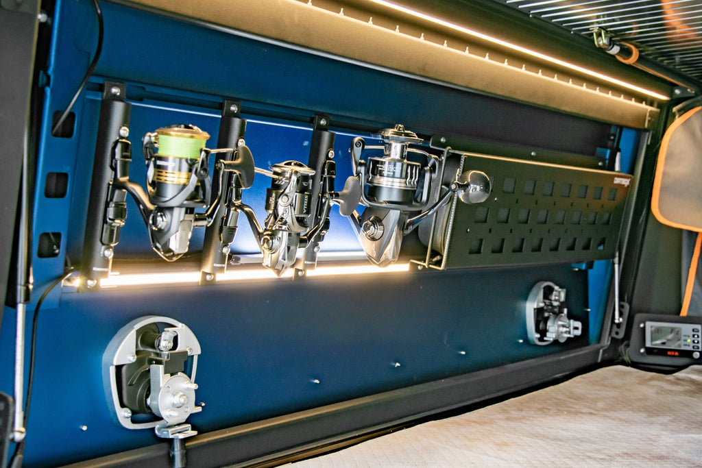 Interior view of a Dirtbox Overland Fishing Reel Mount showing multiple fishing reels secured along the canopy door, showcasing optimal accessibility and space-saving design.