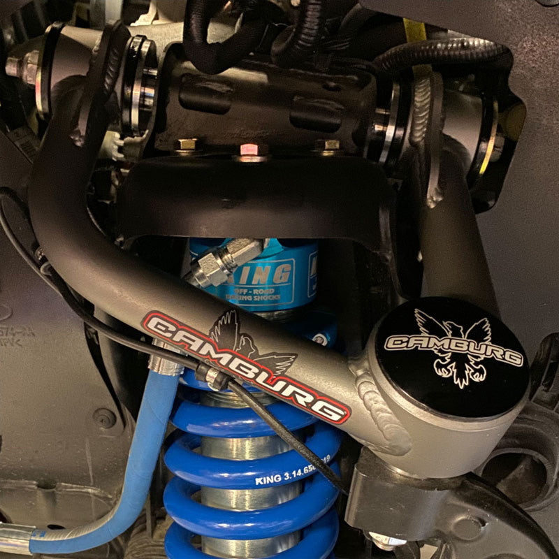 Close-up view of Camburg Performance Uniball Upper Arms installed on a Ford F-150, showcasing enhanced suspension design for 21-23 models.