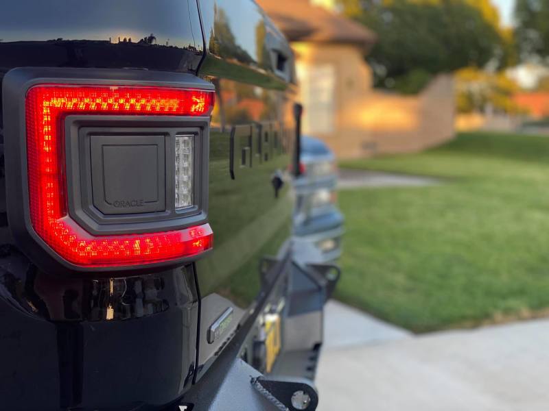 Close-up of Jeep Gladiator JT's rear showcasing ORACLE Lighting Flush Mount LED Tail Lights illuminated.