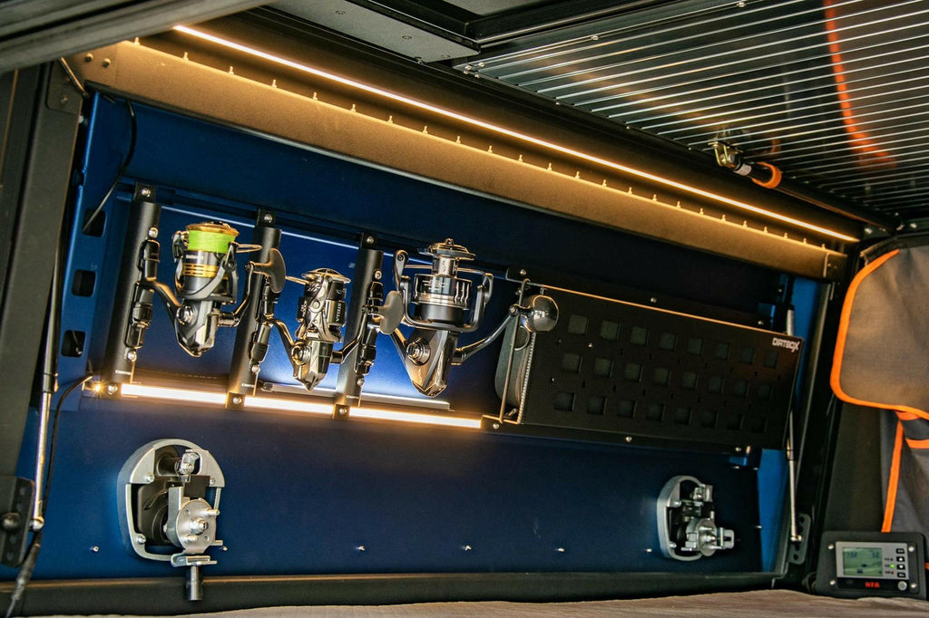 Inside view of the Dirtbox Overland Molle Panel Fishing Rod Case Bundle with mounted fishing reels and gear storage, showcasing a sleek and organized design.