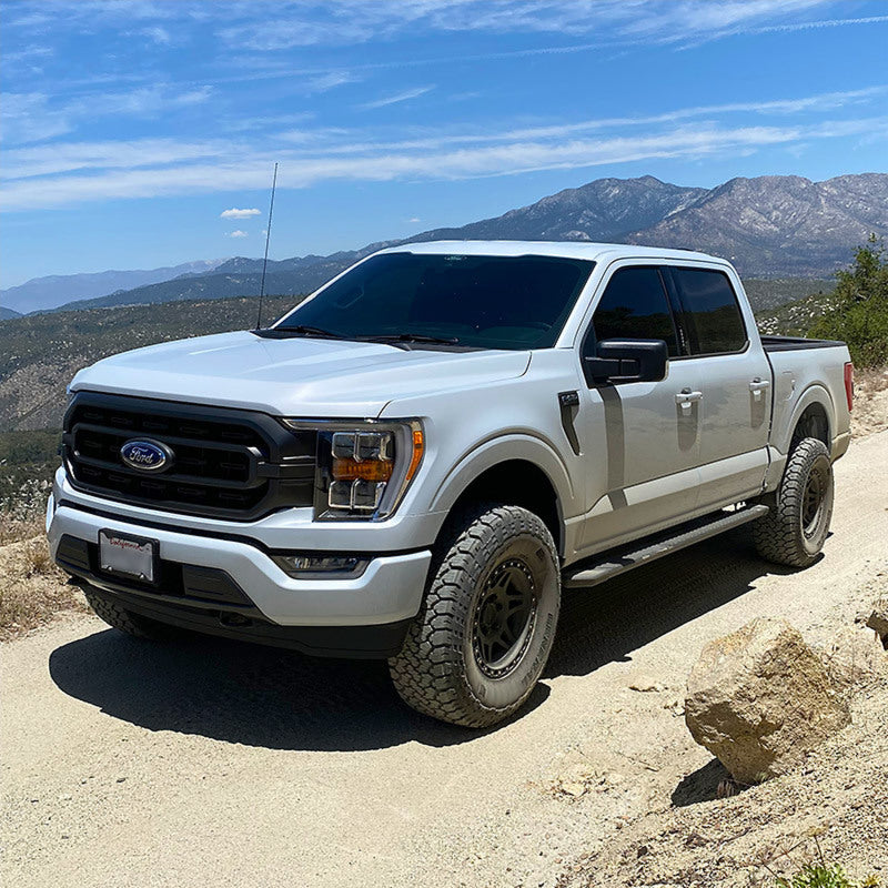 Stylish Ford F-150 off-roading on a mountain trail, equipped with Camburg Performance Uniball Upper Arms for ultimate performance and handling.
