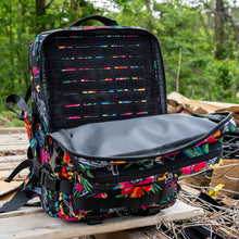 Load image into Gallery viewer, A person hiking with the Combat Iron Apparel 25L Sack™ Original All-Day Molle Backpack with Pouch in a beautiful green setting.