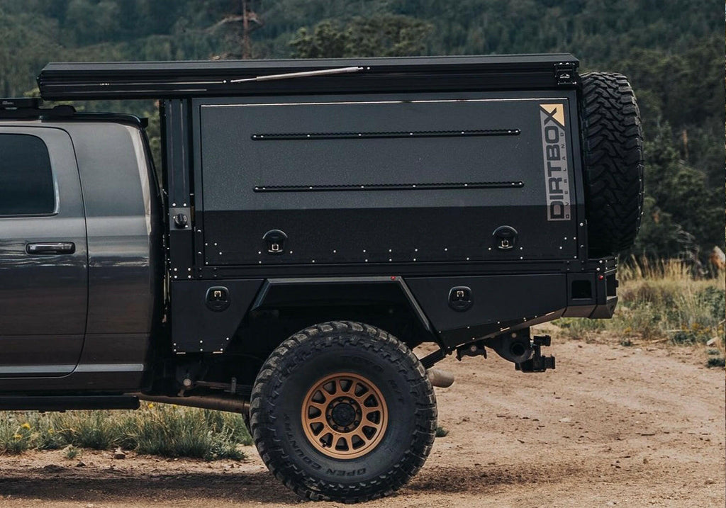 Close-up of the Dirtbox Overland Flatbed System Camper Box on a pickup truck, highlighting its durable exterior and ample storage for outdoor adventures.
