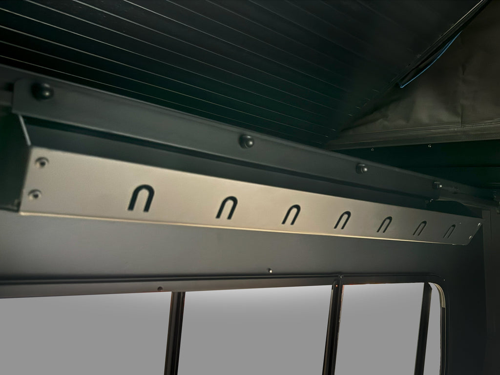 Close-up of Inner Storage accessory by Dirtbox Overland, showcasing a durable hanging rack for clothing in a vehicle, optimized for outdoor adventure.