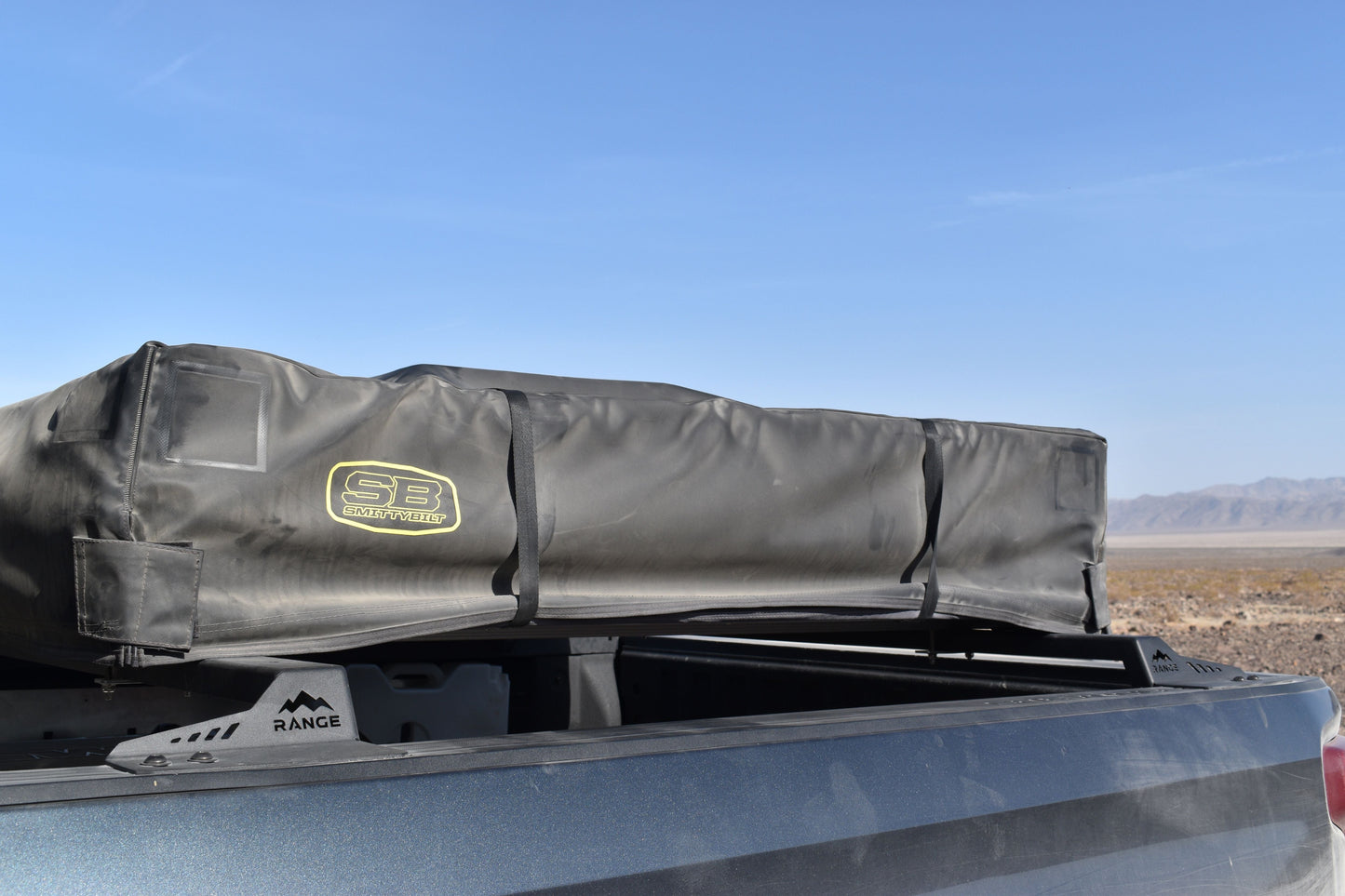 2019+ Silverado/Sierra 1500 Low Profile Tent Rack by Range Industries with a rooftop tent in a desert landscape.