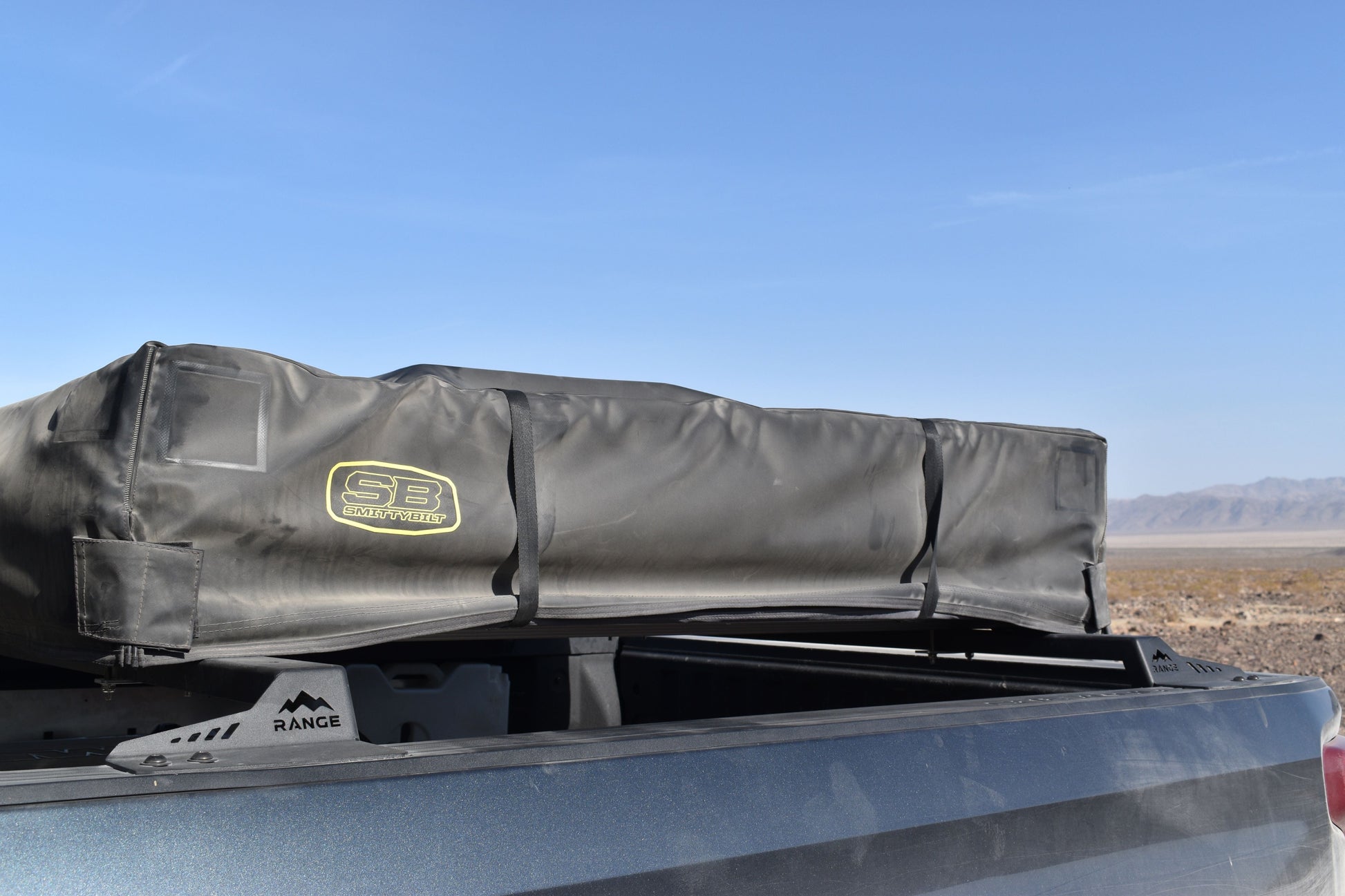 2019+ Silverado/Sierra 1500 Low Profile Tent Rack by Range Industries with a rooftop tent in a desert landscape.
