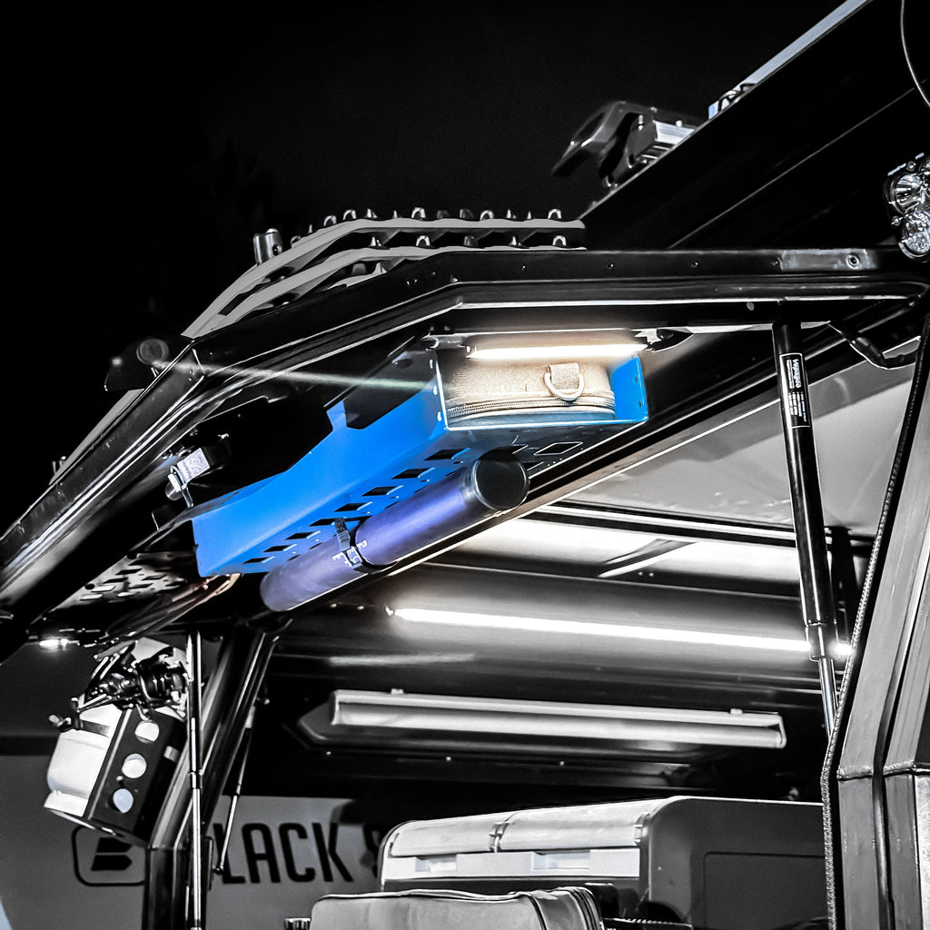 Dirtbox Overland Limited Drop Color Coated Molle Panel Fishing Rod Case Bundle mounted inside a vehicle's gullwing door.