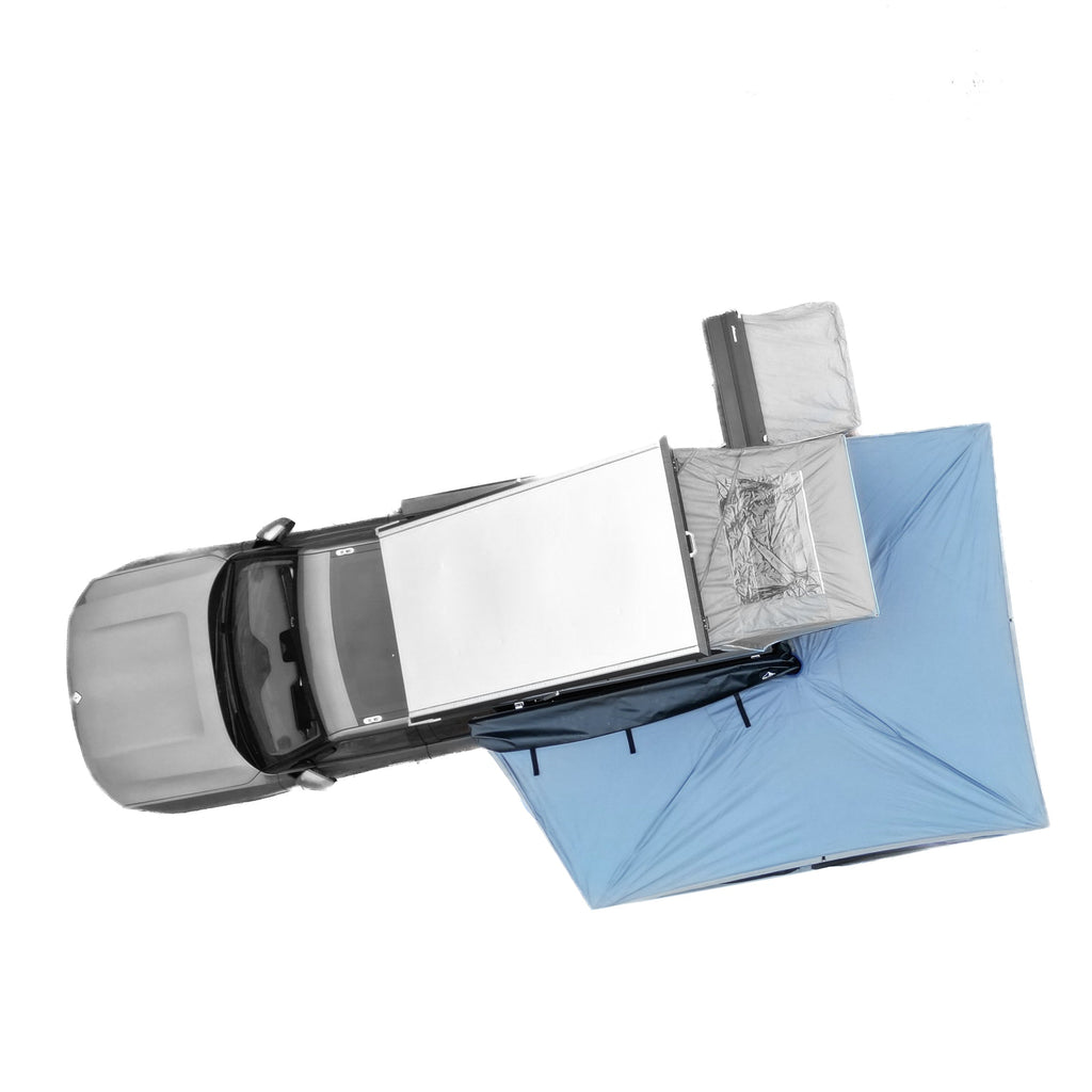Aerial view of a Dirtbox Overland Free Standing 270-Degree Awning set up next to a truck, showcasing its expansive shade coverage over outdoor camping gear.