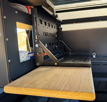 Load image into Gallery viewer, Dirtbox Overland Folding Camp Table with Cutting Board &amp; Side Molle Box - Table with integrated cutting board setup in a camper.