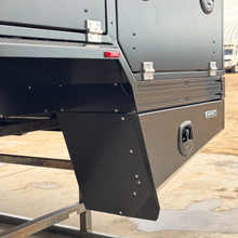 Load image into Gallery viewer, Close-up of the Transformer Drop Center Flatbed by DirtBox Overland, showcasing heavy-duty extrusions and utility storage compartments, designed for overland adventures.