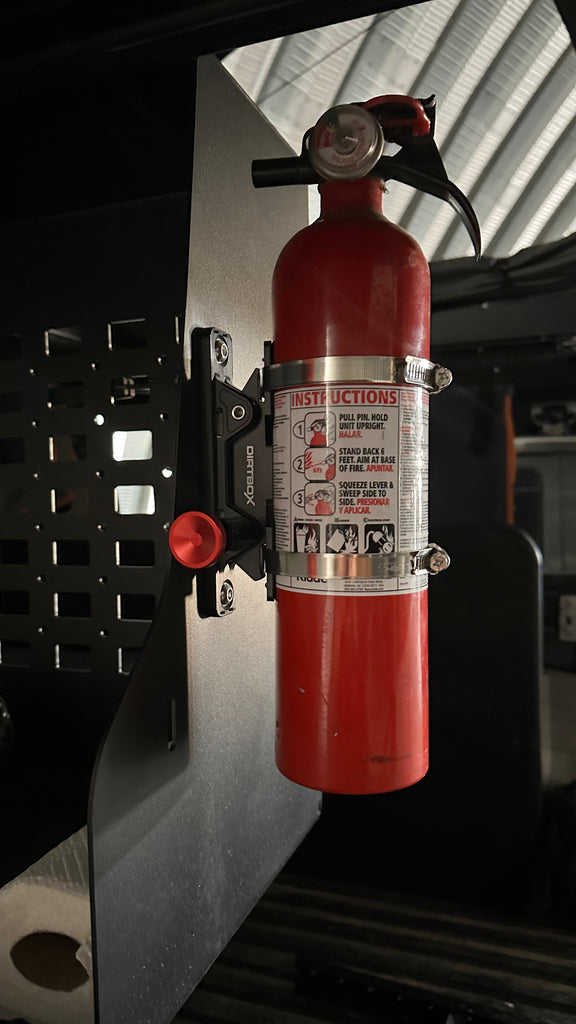 Dirtbox Overland Quick Release Fire Extinguisher Mount with a mounted fire extinguisher. Precision-machined design for off-road safety and easy access. Perfect for any adventure.