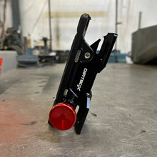 Load image into Gallery viewer, Dirtbox Overland Quick Release Fire Extinguisher Mount displayed at an angle, featuring precision-machined black aluminum with a red quick release knob.