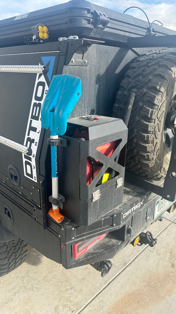 Close-up of the Dirtbox Overland Jerry Can Holder attached to an off-road vehicle, highlighting its secure fit and usability for fuel or water storage.