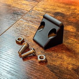 Canopy Camper Rear Camera Relocation Mount by Dirtbox Overland with metal screws and nuts on a wooden surface.