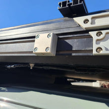 Load image into Gallery viewer, The Chunk Quick Release Bracket by Dirtbox Overland displayed on a roof rack, emphasizing its durability and sleek aesthetic.