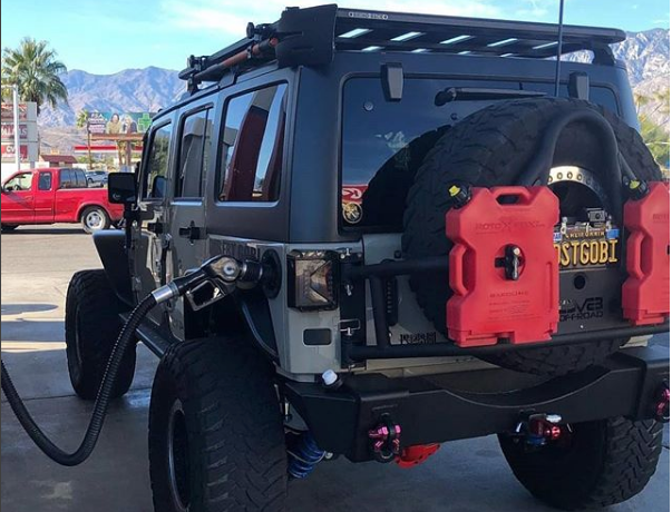 Jeep with a 2 Gallon Gasoline container by RotopaX mounted on the back, showcasing its practical use for off-road adventures.