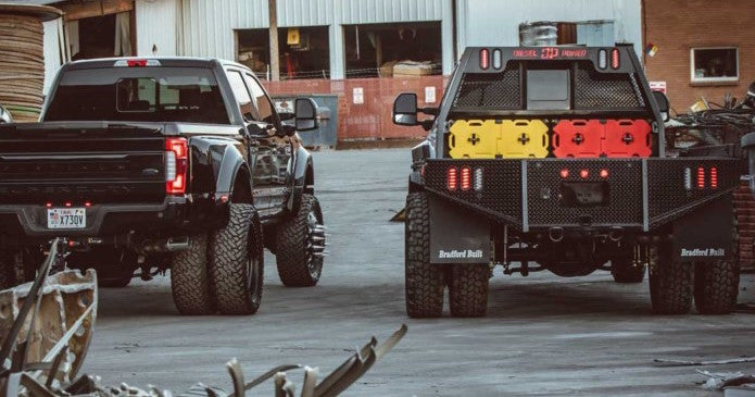 Image of trucks parked side by side with multiple 2 Gallon Diesel containers by RotopaX securely mounted on the rear, emphasizing outdoor utility.