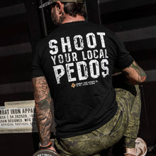 Load image into Gallery viewer, Side view of a man wearing a black t-shirt with 'Shoot Your Local Pedos' in white letters on the back, from Combat Iron Apparel.