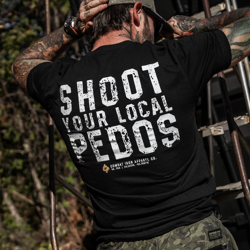 Close-up of a black t-shirt showing the back print 'Shoot Your Local Pedos', designed by Combat Iron Apparel.