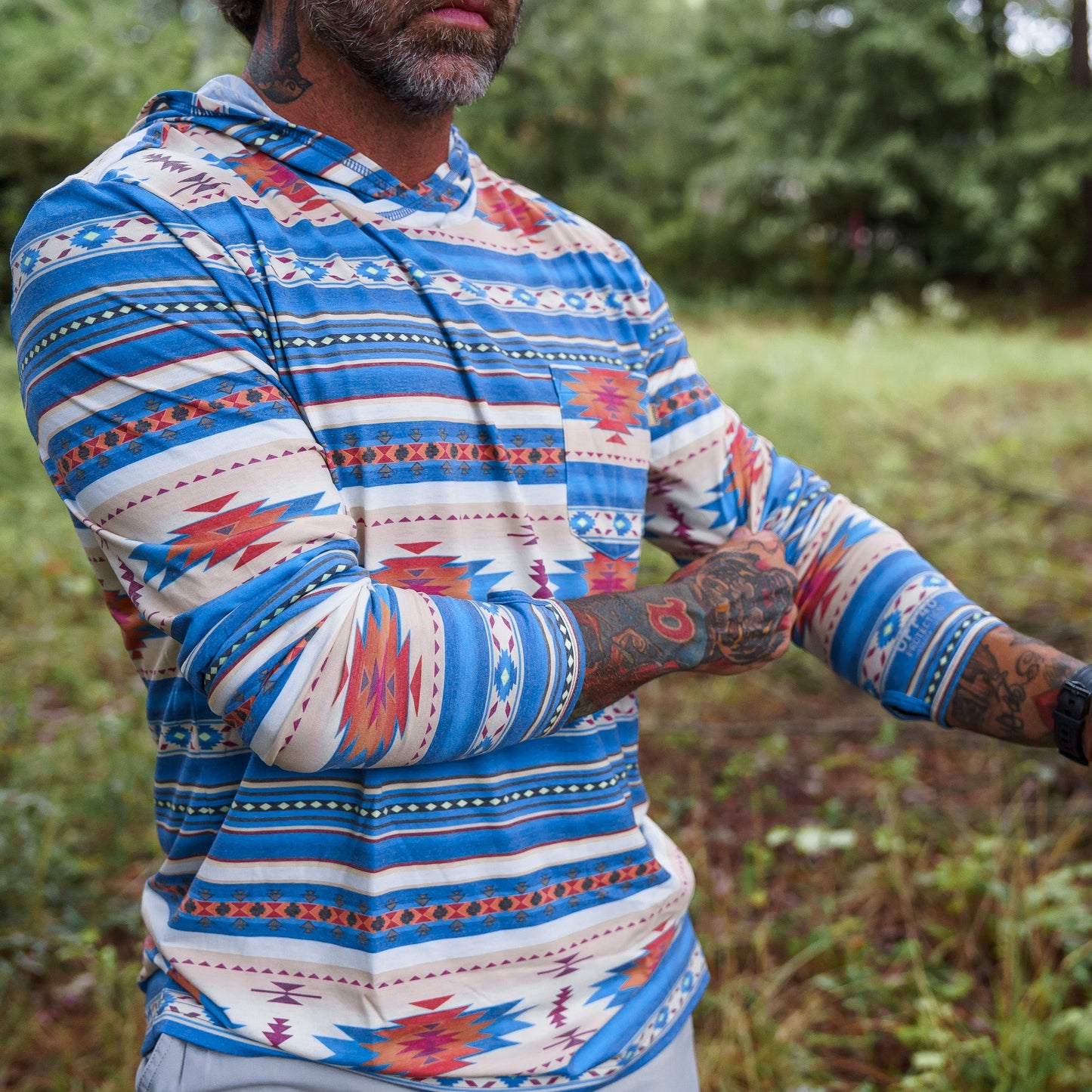 A close-up of a man in Men's Outdoors Long Sleeve Performance Hoodie by Combat Iron Apparel, showing the intricate fabric detail.