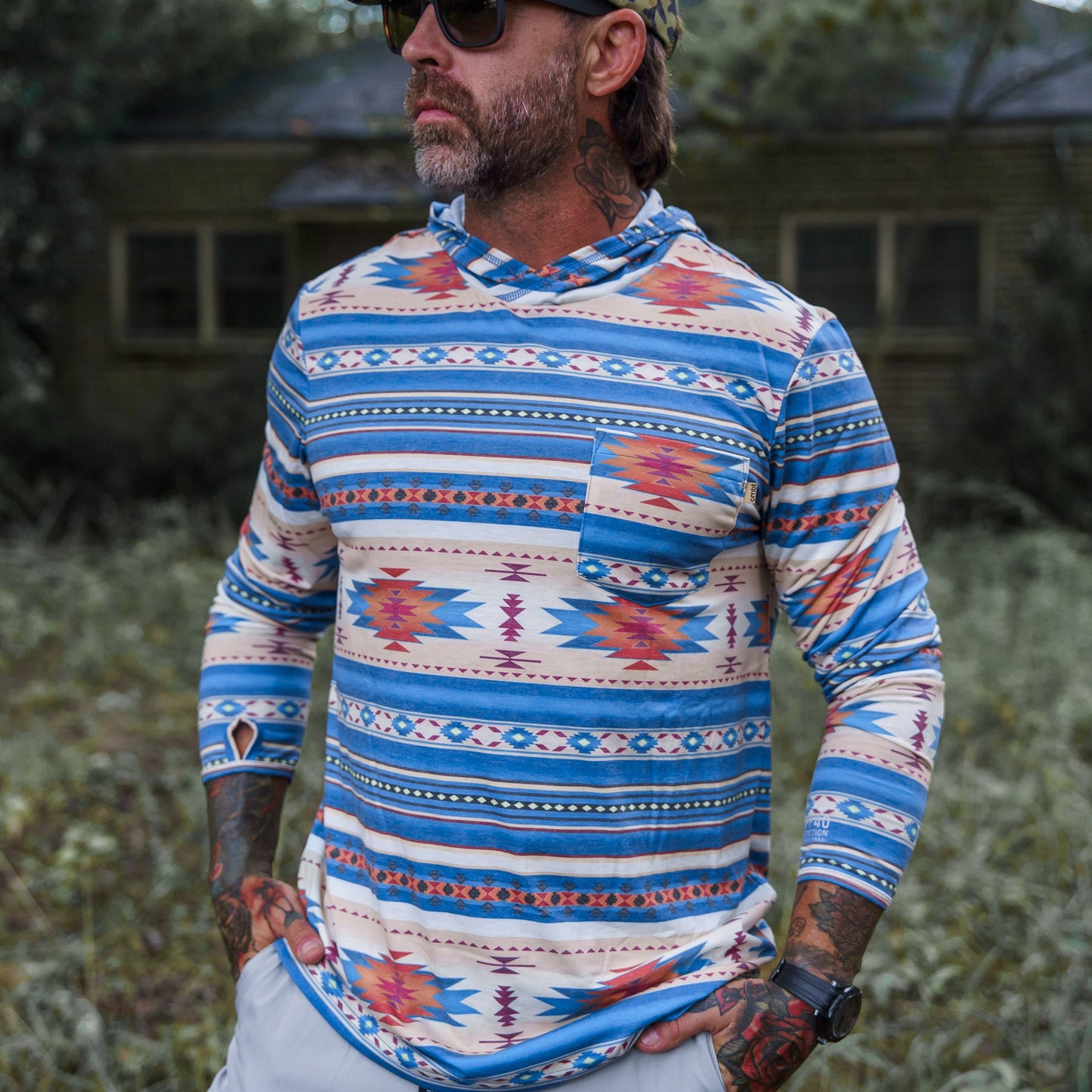 A man's close-up in the vibrant Men's Outdoors Long Sleeve Performance Hoodie by Combat Iron Apparel, highlighting textile quality.