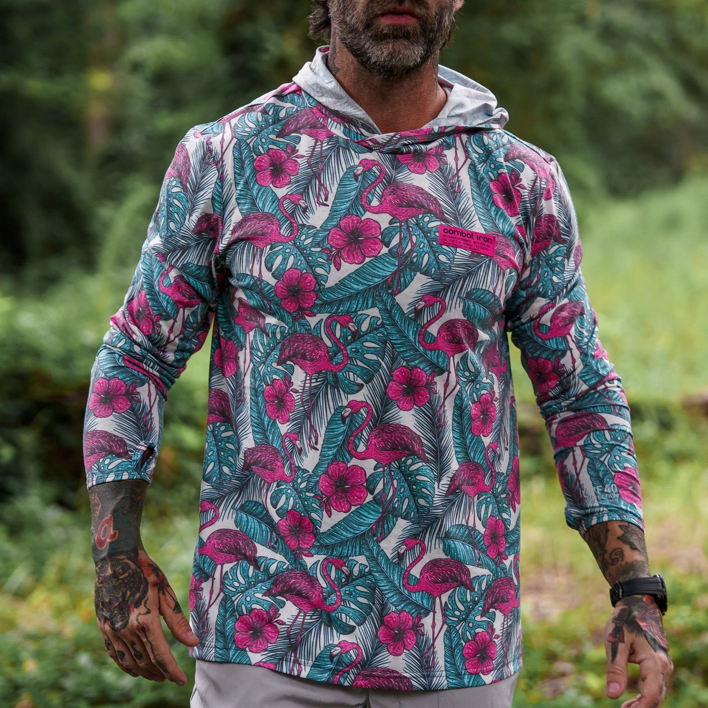 A model wearing the camo design Men's Outdoors Long Sleeve Performance Hoodie by Combat Iron Apparel in action.