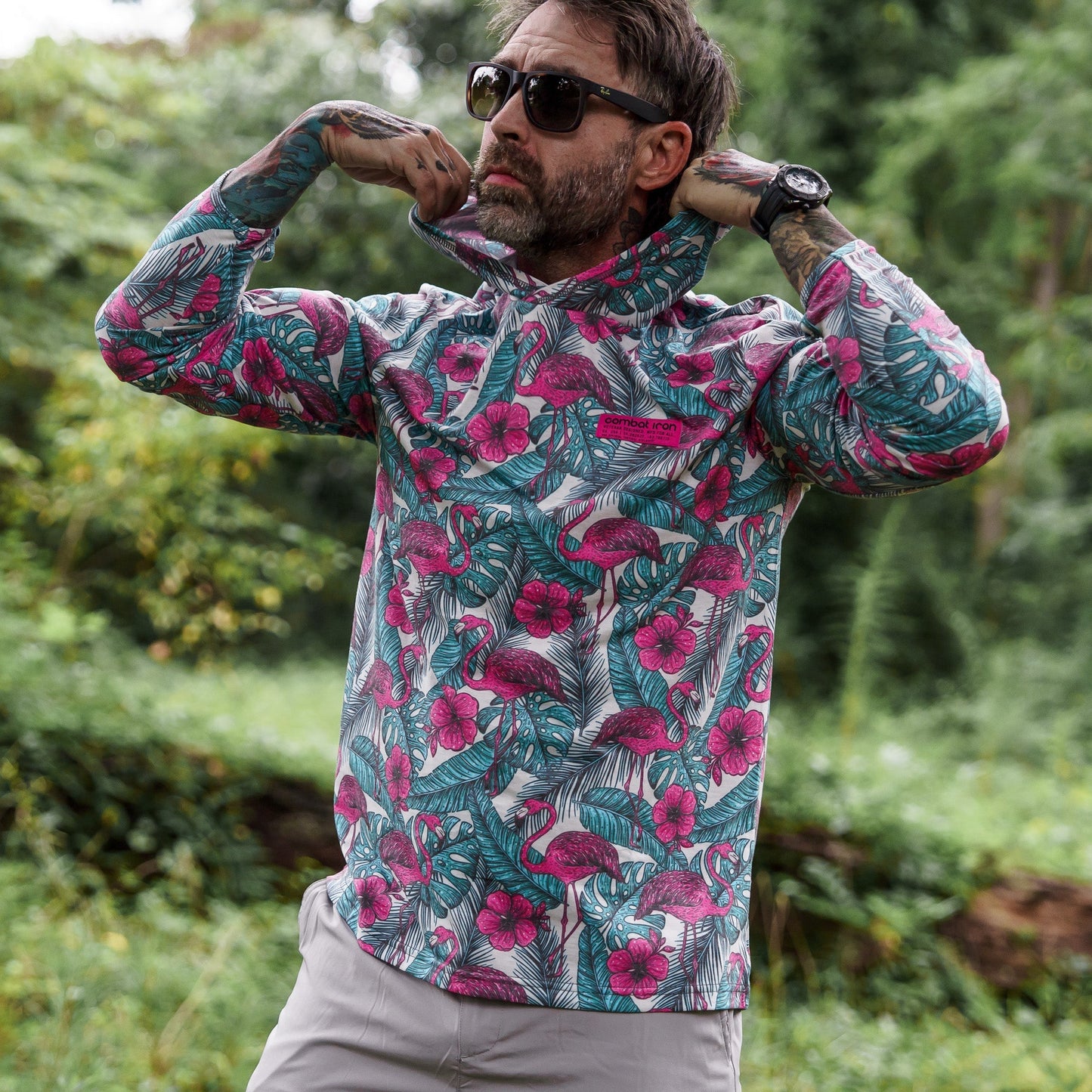 Men's Outdoors Long Sleeve Performance Hoodie by Combat Iron Apparel, modeled outdoors while showcasing its colorful design.