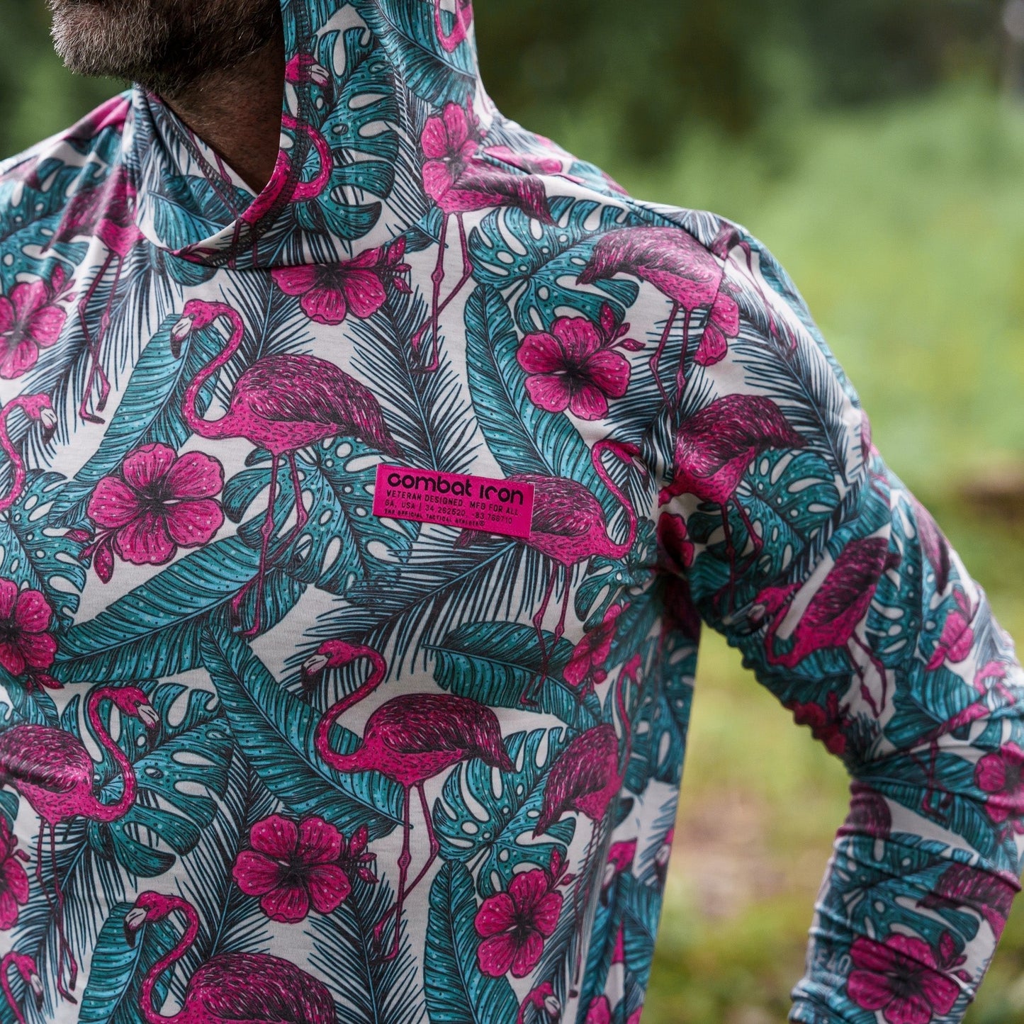 A model wears the Men's Outdoors Long Sleeve Performance Hoodie by Combat Iron Apparel while demonstrating its fit in nature.