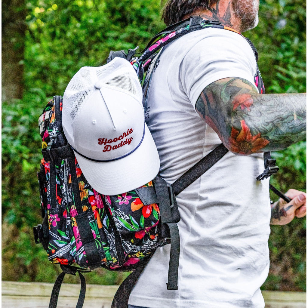 The vibrant floral design of the Combat Iron Apparel 25L Sack™ Original All-Day Molle Backpack with Pouch being showcased outdoors.