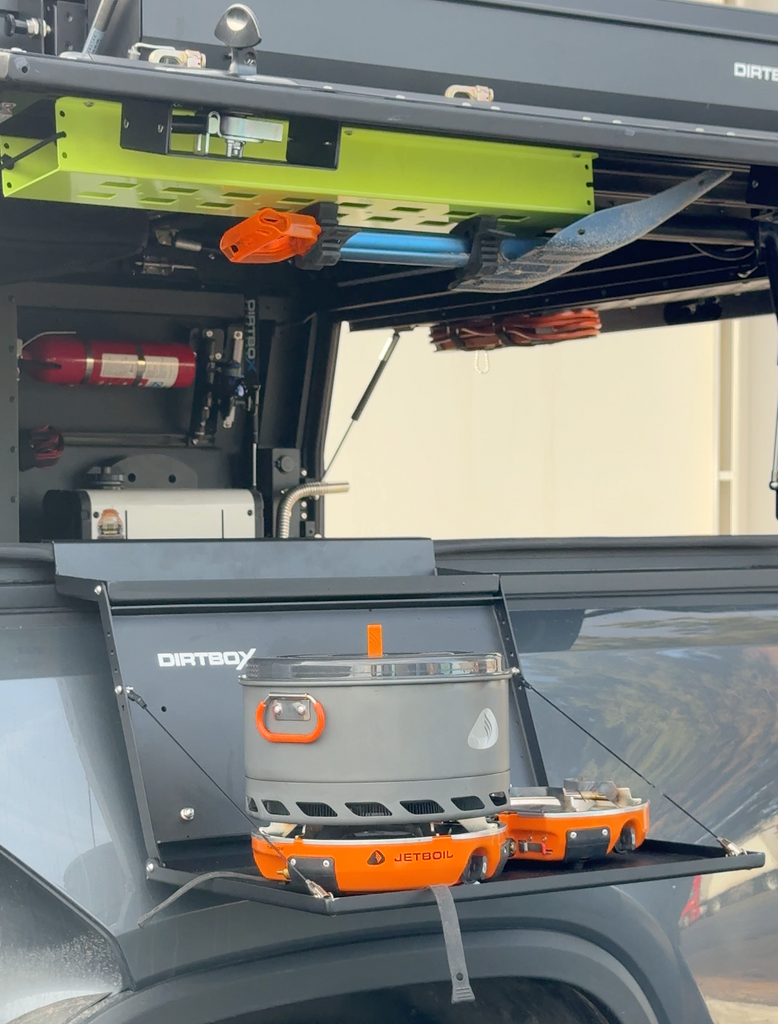 Dirtbox Overland Hitch Hiker Folding Table set up with a Jetboil cooking system in an outdoor setting, showcasing the convenience of outdoor cooking.