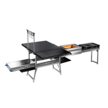 Load image into Gallery viewer, Quick Deploy Ground Kitchen Box by Dirtbox Overland featuring a compact, foldable design with integrated sink, two burners, a cutting board, and built-in table for outdoor cooking convenience.