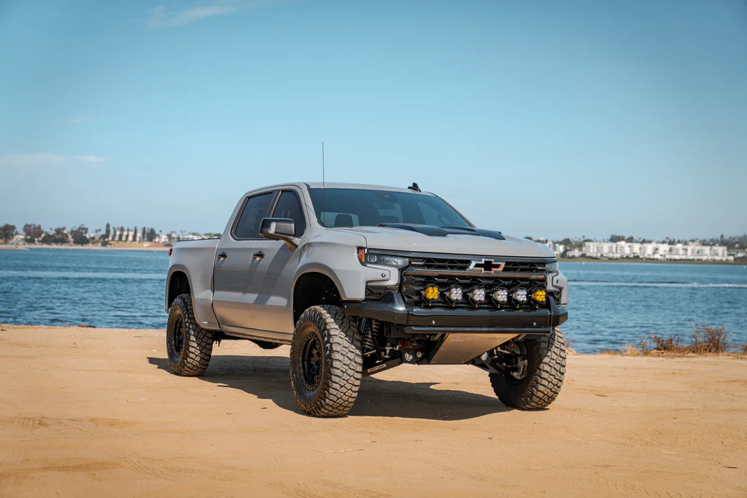 2022-2023 Chevy Silverado ZR2 Carbon Fiber Fenders showcased on a rugged pickup truck by fiber werx near the water, demonstrating its off-road capability and stylish design.