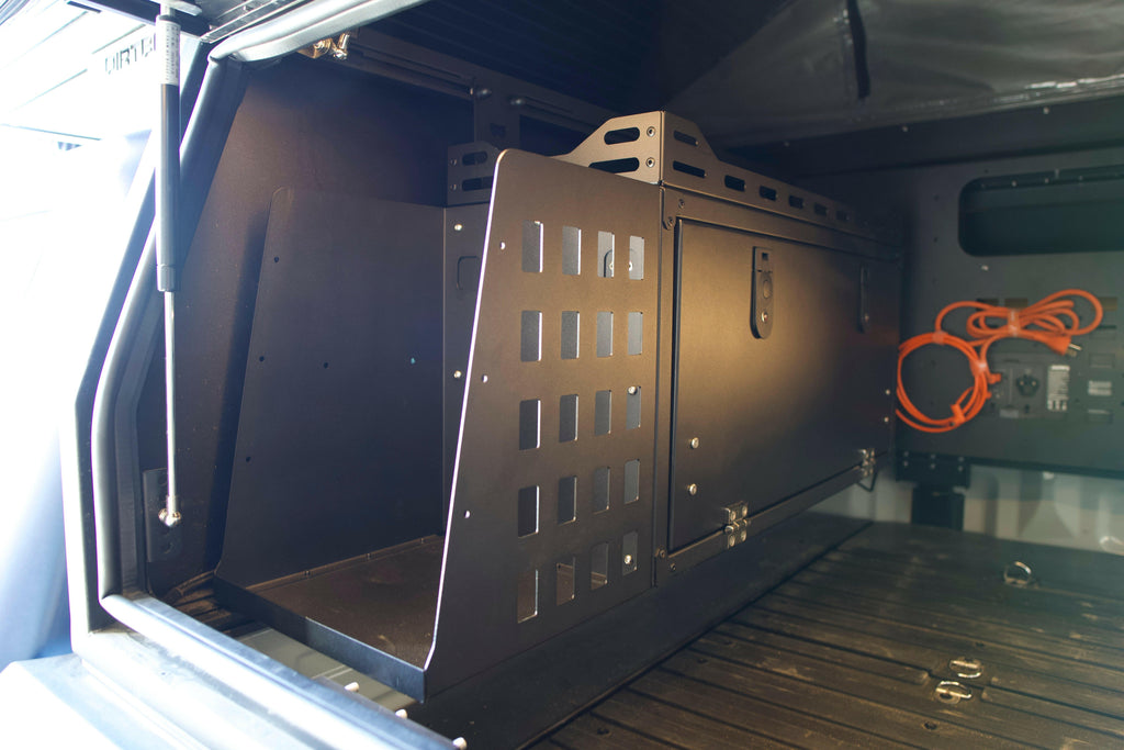Interior view of a Dirtbox Overland Front Storage Box installed in a canopy camper, showcasing its sturdy design and space for outdoor gear.