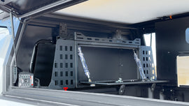 Dirtbox Overland Front Storage Box in black, installed in a camper, highlighting its secure and organized storage solution for outdoor enthusiasts.