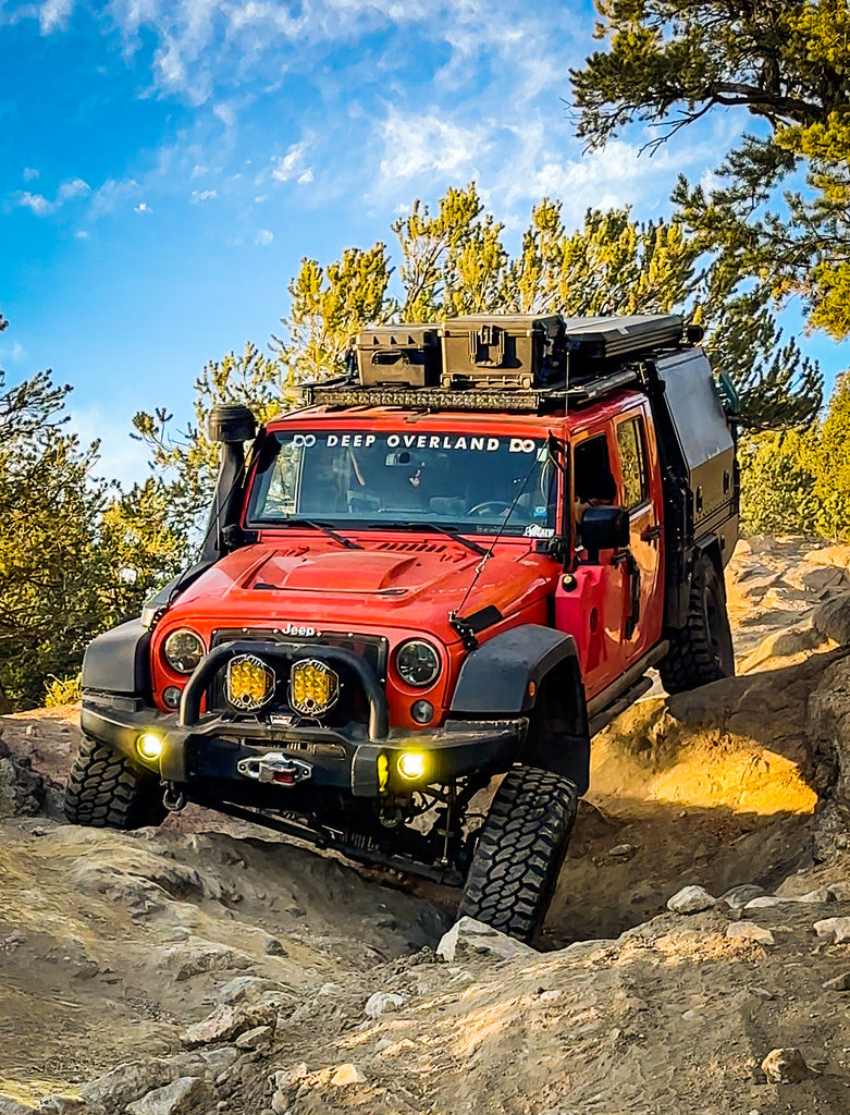 Dirtbox Overland Flatbed System Full Box on a red Jeep conquering rocky trails, showing its adventure-ready features.