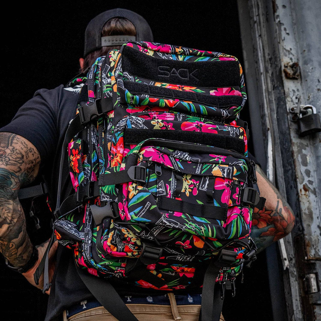 A detailed view of the vibrant floral Combat Iron Apparel 25L Sack™ Original All-Day Molle Backpack with Pouch, showing its pockets and straps.