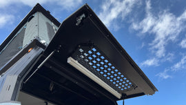 Angle view of the Security Window Molle Panel by Dirtbox Overland mounted on a canopy, displaying its customizable layout for outdoor gear.