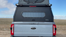 Load image into Gallery viewer, Rear view of a vehicle fitted with the Security Window Molle Panel by Dirtbox Overland, highlighting its protective features and sleek design.