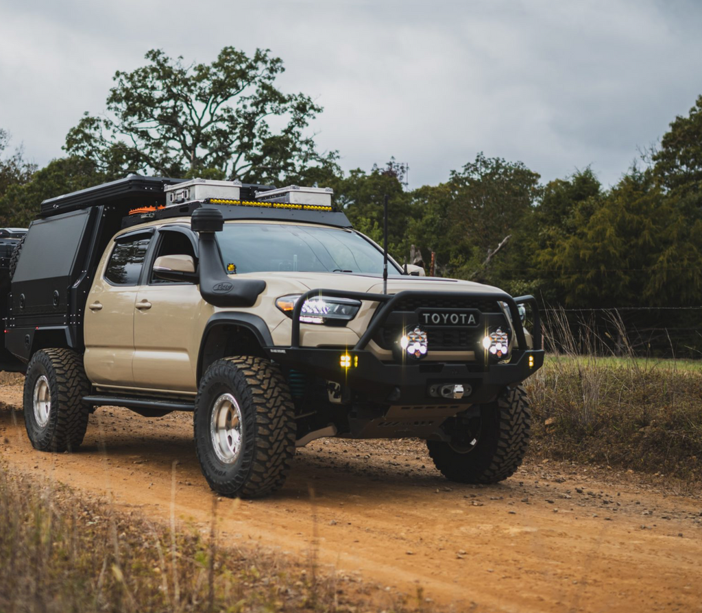 Dirtbox Overland Flatbed System Full Box installed on a rugged beige Toyota truck parked on a dirt road, showcasing off-road capabilities and adventure-ready features.
