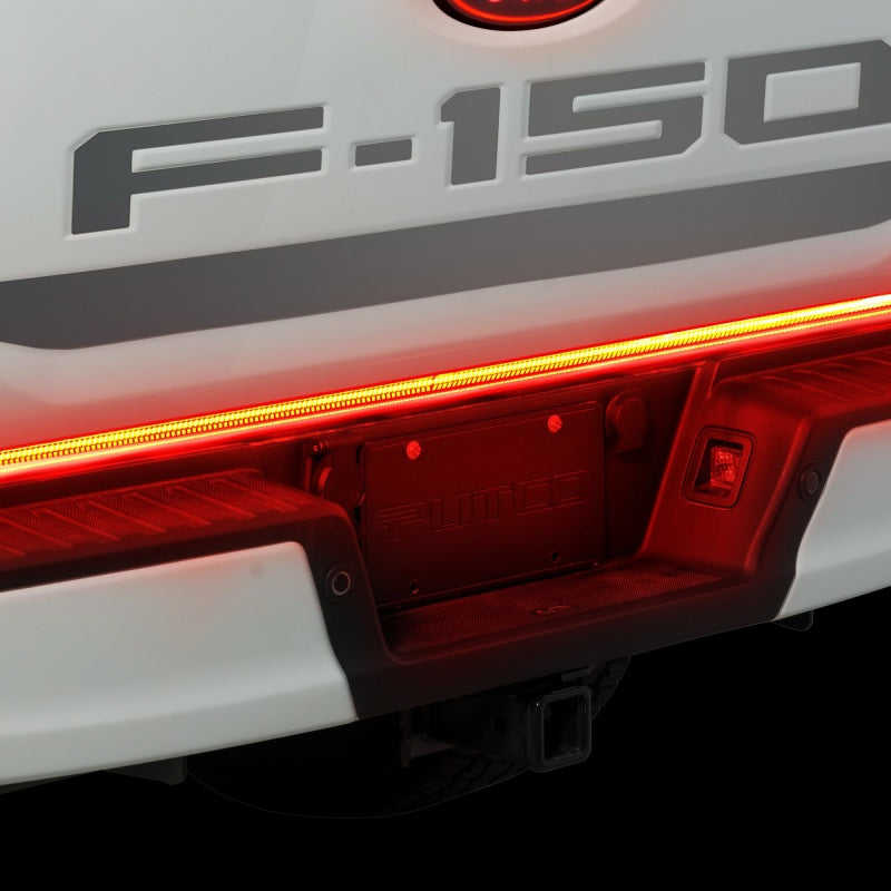 Close-up view of the Putco 21-22 Ford F-150 60in Red Light Blade Direct Fit Kit Red/White illuminating a white Ford F-150 tailgate, featuring a bright red light.