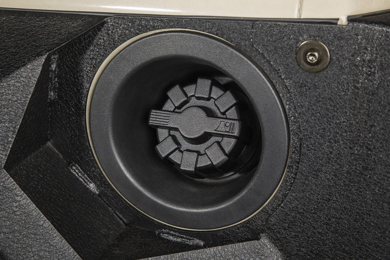 Rugged Ridge 01-19 Jeep Wrangler Black Elite Aluminum Fuel Cap installed in a Jeep's fuel compartment.