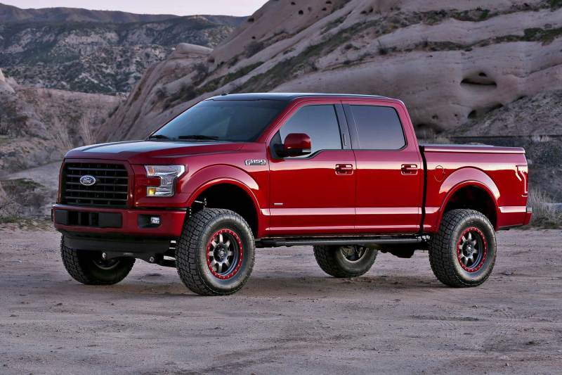 2015-2020 Ford F-150 lifted truck featuring Fabtech 6-inch Performance System, driving through rocky terrain with enhanced off-road capabilities.
