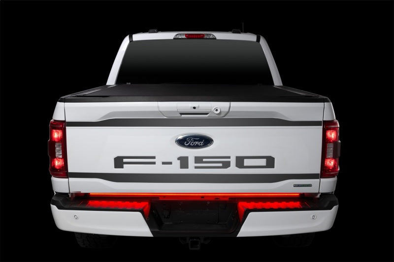 Putco 48-inch Light Blade Direct Fit Kit for Ford Ranger lighting up the tailgate of a white Ford F-150 with bright red lights.